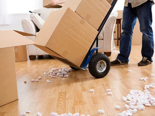 Carrinho de carga transportando caixas pesadas dentro de uma residência